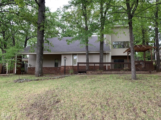 back of property with roof with shingles, a wooden deck, and a yard