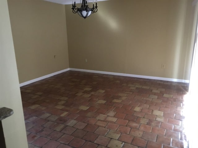 unfurnished dining area featuring baseboards and a notable chandelier