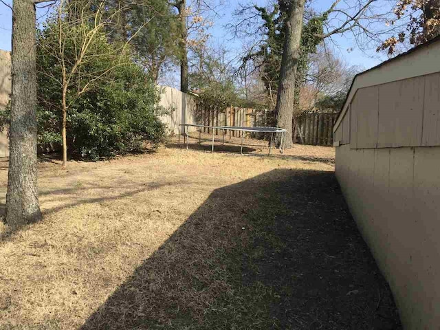 view of yard with a fenced backyard and a trampoline
