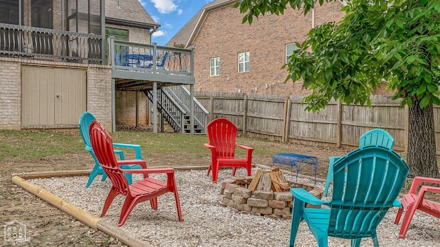 view of playground featuring a fire pit, stairs, a deck, and fence