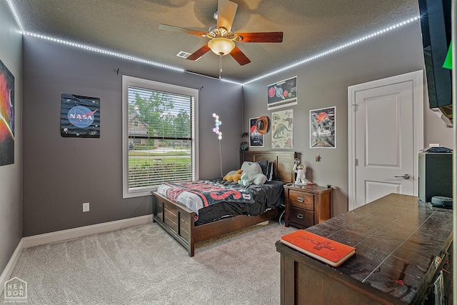 carpeted bedroom with baseboards, ceiling fan, and a textured ceiling