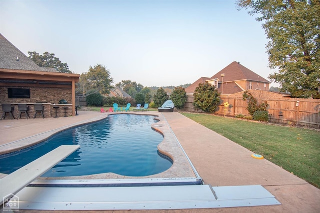 view of swimming pool with a yard, a fenced backyard, outdoor dry bar, a patio area, and a fenced in pool