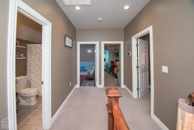 hallway featuring light tile patterned floors, baseboards, visible vents, and recessed lighting