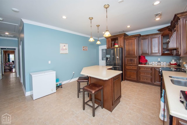 kitchen featuring a center island, stainless steel fridge, ornamental molding, light countertops, and refrigerator