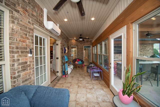 sunroom featuring an AC wall unit and a ceiling fan