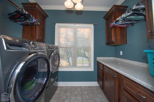 laundry area with light tile patterned floors, washer and clothes dryer, crown molding, and cabinet space