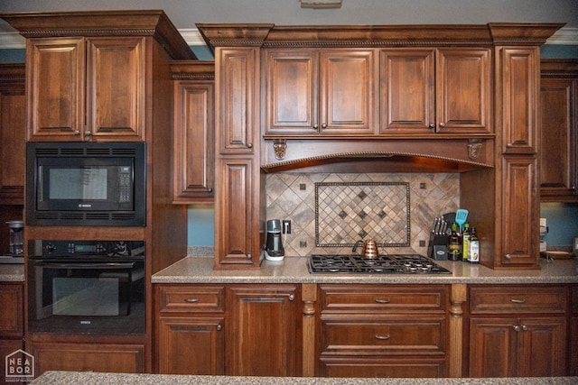 kitchen featuring light countertops, backsplash, and black appliances