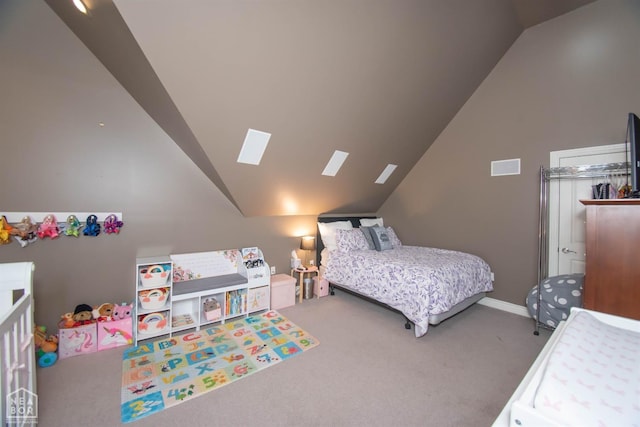 carpeted bedroom with vaulted ceiling with skylight, baseboards, and visible vents