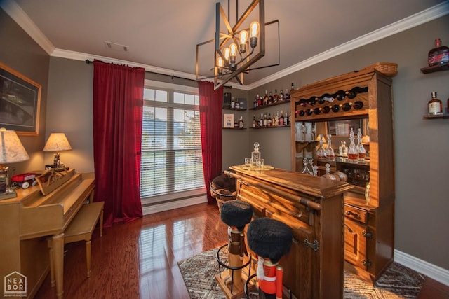 bar featuring crown molding, an inviting chandelier, visible vents, a bar, and wood finished floors