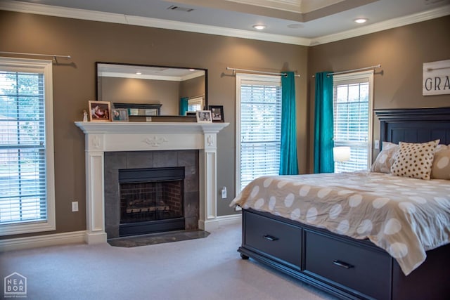 carpeted bedroom featuring baseboards, crown molding, a fireplace, and visible vents