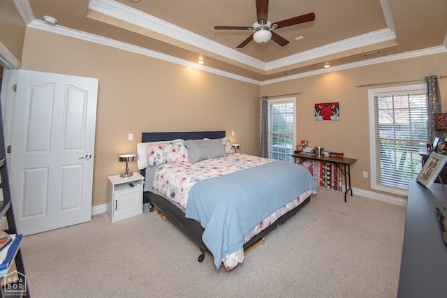 bedroom featuring a tray ceiling, crown molding, light colored carpet, and baseboards