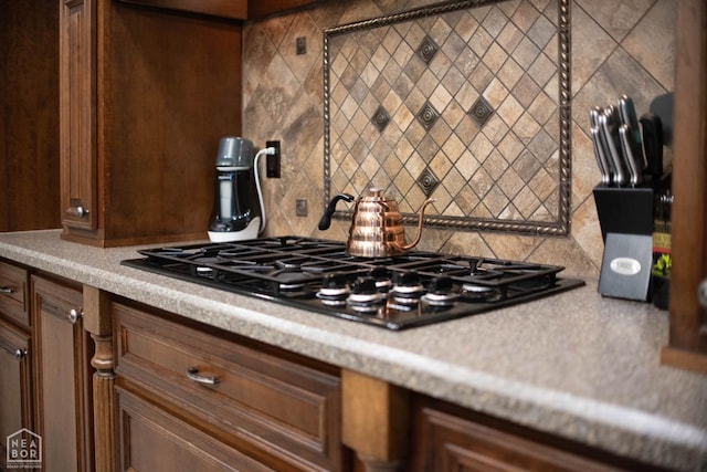 kitchen featuring black gas stovetop and backsplash