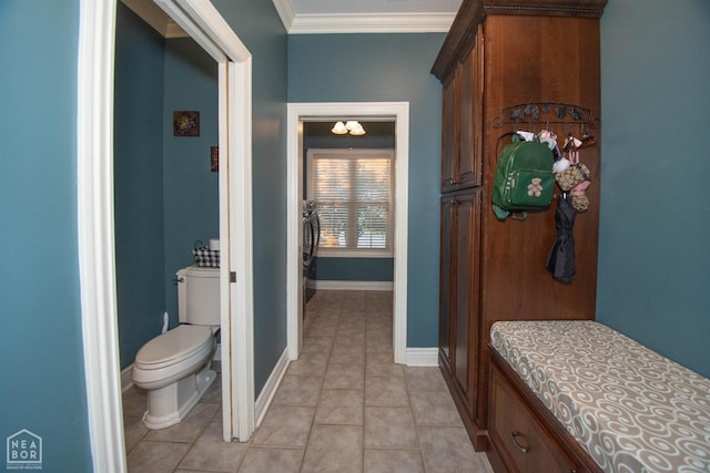 bathroom featuring crown molding, toilet, tile patterned flooring, and baseboards