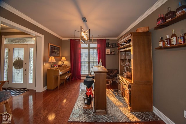 dining space featuring a chandelier, crown molding, wood finished floors, and baseboards