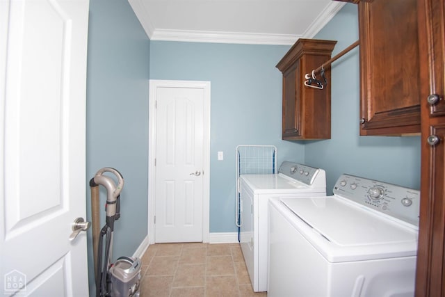 washroom with light tile patterned floors, baseboards, crown molding, cabinet space, and washing machine and clothes dryer