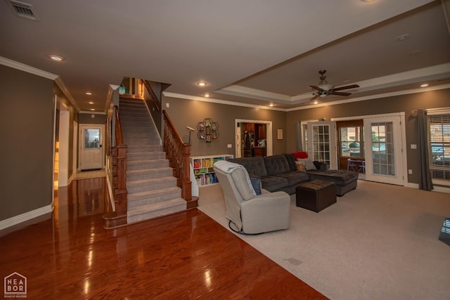 living area with recessed lighting, stairway, ornamental molding, and a raised ceiling