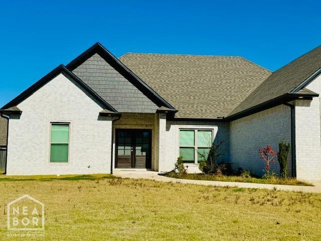 3803 Stone Ridge Dr, Paragould, AR 72450 - back of house featuring brick siding, a lawn, and french doors