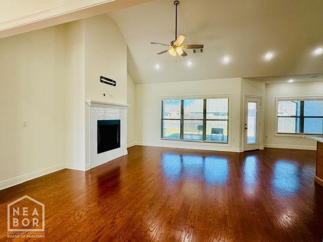 3803 Stone Ridge Dr, Paragould, AR 72450 - unfurnished living room featuring a ceiling fan, a fireplace, baseboards, wood finished floors, and high vaulted ceiling