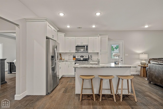 3604 Fieldstone Dr, Paragould, AR 72450 - kitchen featuring stainless steel appliances, white cabinetry, light stone countertops, tasteful backsplash, and recessed lighting