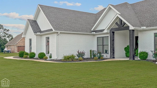 3604 Fieldstone Dr, Paragould, AR 72450 - view of front of house featuring brick siding, board and batten siding, a front lawn, and an attached garage