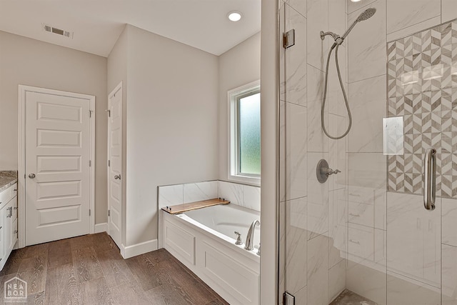 3604 Fieldstone Dr, Paragould, AR 72450 - full bathroom with a stall shower, a bath, wood finished floors, and vanity