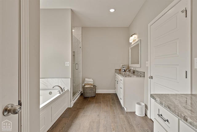 3604 Fieldstone Dr, Paragould, AR 72450 - bathroom with vanity, a stall shower, a bath, wood finished floors, and recessed lighting