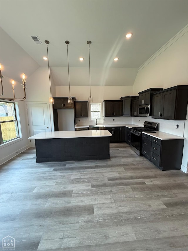 3101 Bear Creek Cv, Jonesboro, AR 72404 - kitchen with appliances with stainless steel finishes, lofted ceiling, a center island, light countertops, and light wood-style floors
