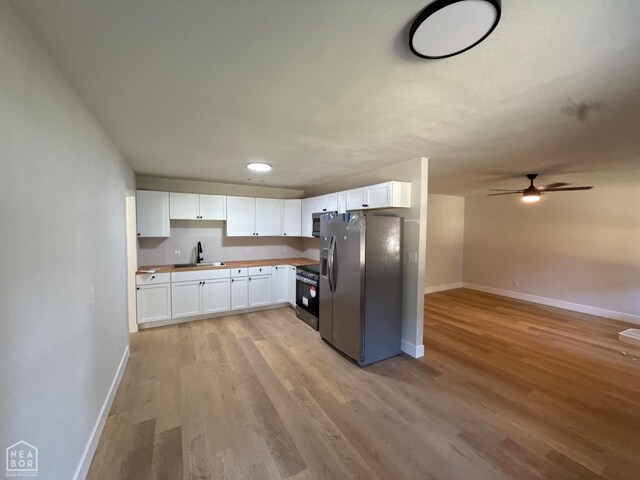 2408 Harper St, Corning, AR 72422 - kitchen with appliances with stainless steel finishes, light wood-type flooring, white cabinets, a ceiling fan, and open floor plan