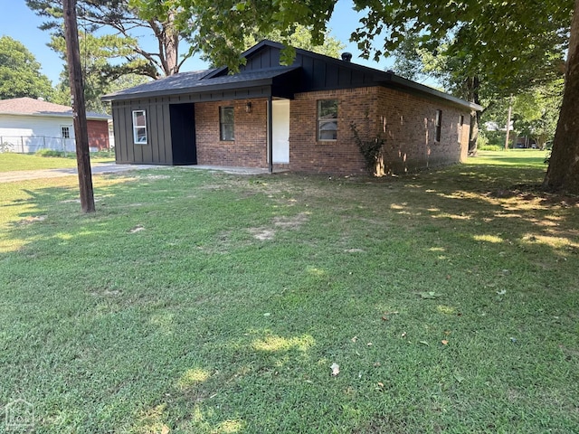 2408 Harper St, Corning, AR 72422 - view of front facade with board and batten siding, brick siding, and a front yard