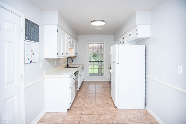 2209 Greensboro Rd, Jonesboro, AR 72405 - kitchen featuring freestanding refrigerator, a sink, light countertops, and white cabinets