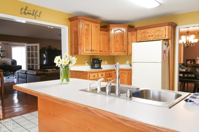 2311 Bridger Rd, Jonesboro, AR 72405 - kitchen with freestanding refrigerator, light countertops, light tile patterned flooring, a chandelier, and open floor plan
