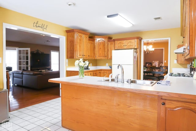 2311 Bridger Rd, Jonesboro, AR 72405 - kitchen featuring freestanding refrigerator, range hood, light countertops, light tile patterned floors, and a peninsula