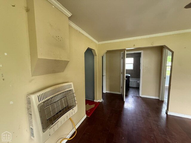 414 E 1st St, Rector, AR 72461 - unfurnished living room featuring heating unit, crown molding, baseboards, arched walkways, and wood finished floors