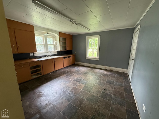 414 E 1st St, Rector, AR 72461 - kitchen with baseboards, open shelves, a sink, dark stone finish flooring, and ornamental molding