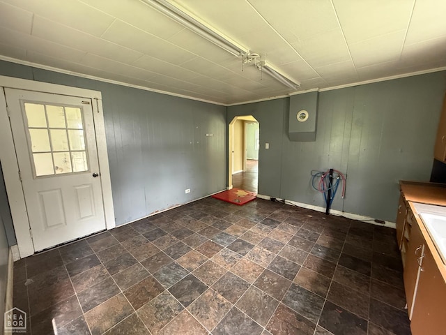 414 E 1st St, Rector, AR 72461 - unfurnished dining area with arched walkways, crown molding, wooden walls, and baseboards
