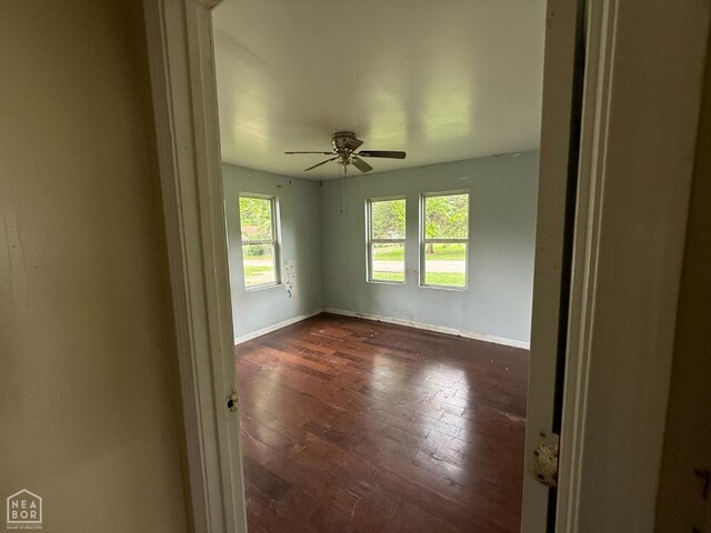 414 E 1st St, Rector, AR 72461 - empty room with healthy amount of natural light, baseboards, a ceiling fan, and dark wood-type flooring