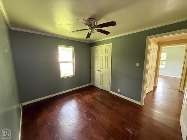 414 E 1st St, Rector, AR 72461 - unfurnished bedroom featuring multiple windows, baseboards, dark wood-type flooring, and ornamental molding
