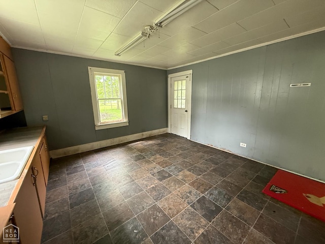 414 E 1st St, Rector, AR 72461 - unfurnished dining area featuring a sink, ornamental molding, dark stone finish floors, and baseboards