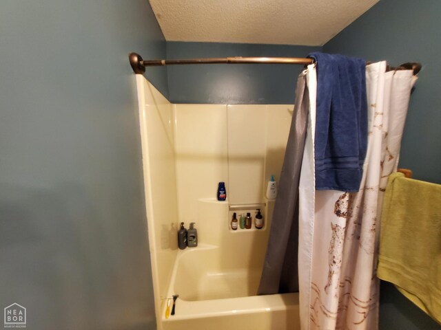 800 Hilltop Dr, Piggott, AR 72454 - full bathroom featuring a textured ceiling and shower / bath combo with shower curtain