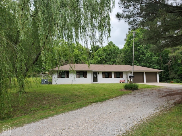 800 Hilltop Dr, Piggott, AR 72454 - single story home with gravel driveway, an attached garage, a front lawn, and a view of trees