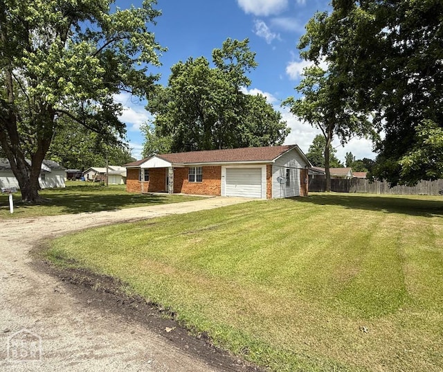 ranch-style house with a front yard, fence, a garage, and driveway