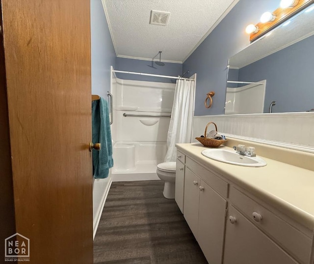 bathroom with wood finished floors, a wainscoted wall, a shower with shower curtain, visible vents, and ornamental molding