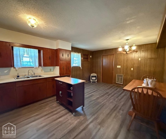 kitchen with wood finished floors, a sink, open shelves, a textured ceiling, and light countertops