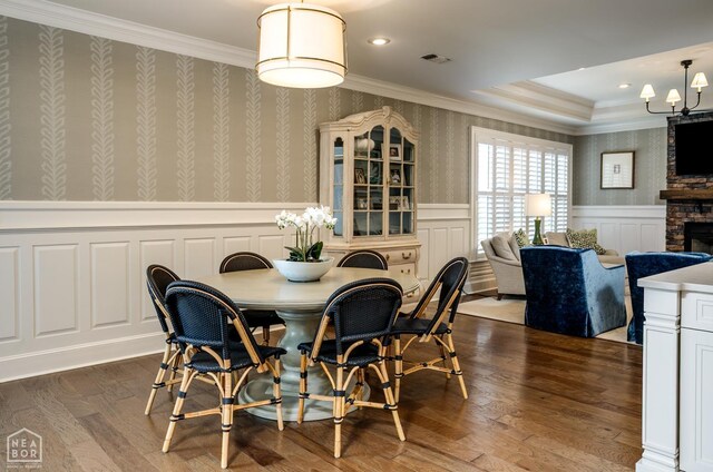 1203 Dove Rd, Jonesboro, AR 72401 - dining area featuring a chandelier, wallpapered walls, wainscoting, crown molding, and a stone fireplace