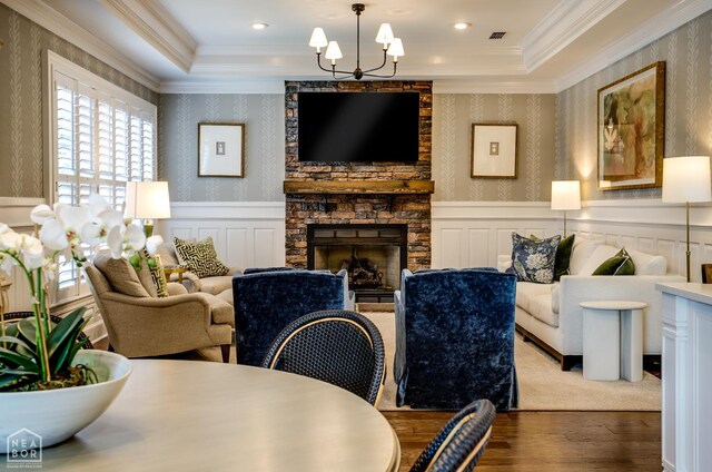 1203 Dove Rd, Jonesboro, AR 72401 - living area featuring wood finished floors, wallpapered walls, a chandelier, a stone fireplace, and a wainscoted wall