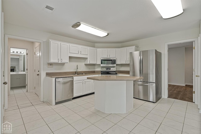 4604 Stillwater, Jonesboro, AR 72404 - kitchen featuring stainless steel appliances, light tile patterned floors, a sink, and white cabinets
