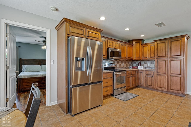 5007 S 28th St, Paragould, AR 72450 - kitchen with stainless steel appliances, brown cabinetry, backsplash, ceiling fan, and recessed lighting