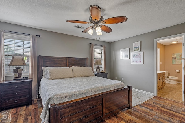 5007 S 28th St, Paragould, AR 72450 - bedroom featuring dark wood finished floors, baseboards, a textured ceiling, connected bathroom, and a ceiling fan