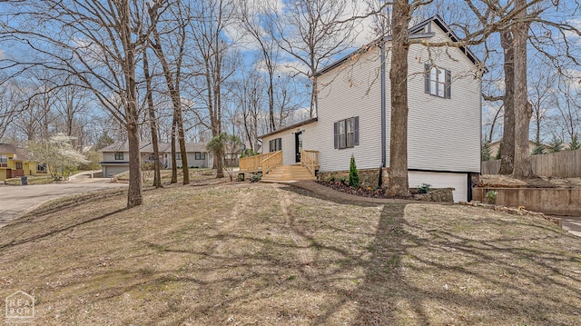 view of side of property featuring an attached garage and fence