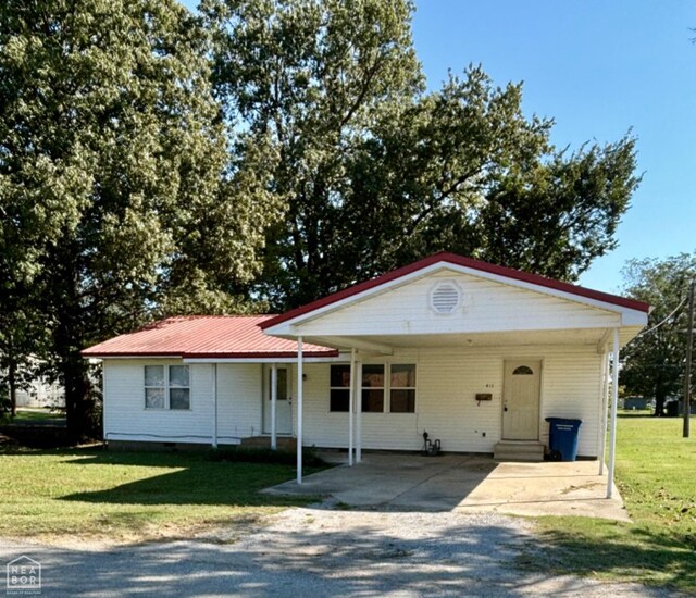 411 S Greenville St, Rector, AR 72461 - view of front of house with a carport, driveway, a front yard, entry steps, and metal roof